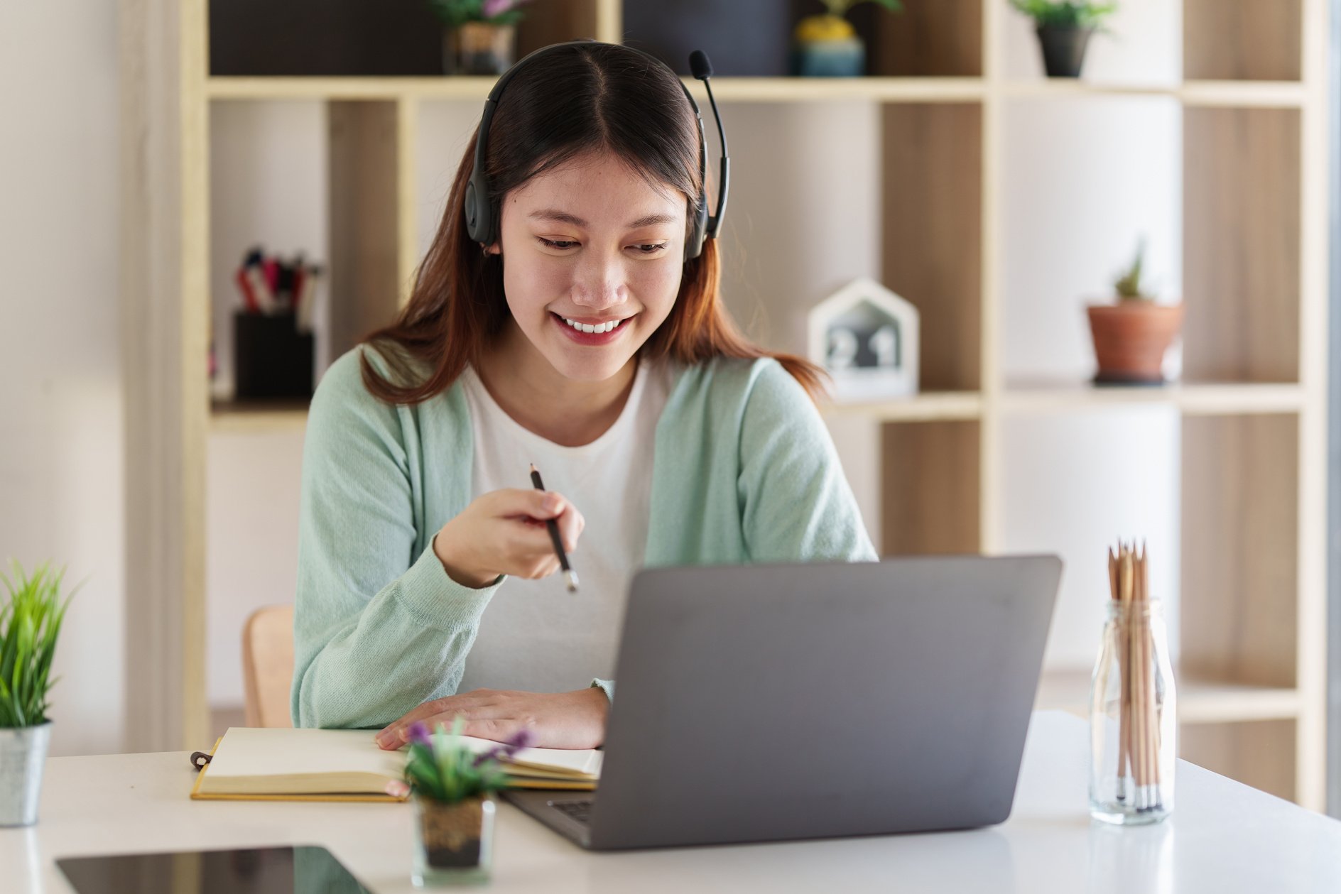 Smiling Asian Attentive Student Studying Online Class. E-Learnin